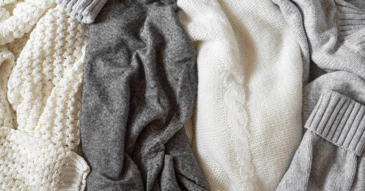January Blog 2 Pic 1 A collection of soft white and grey knit sweaters showing clean fabric textures as a result of using a natural fabric softener alternative.