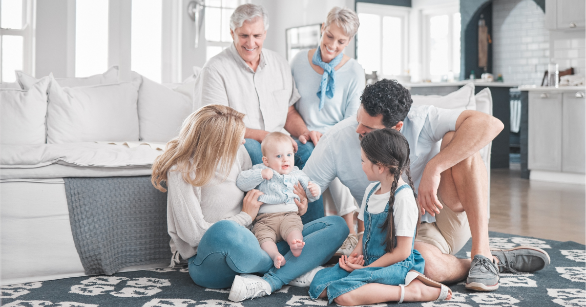 rug care - The WashRoom Laundry Service A multi-generational family seated on a patterned area rug, symbolizing a clean and comfortable living space.