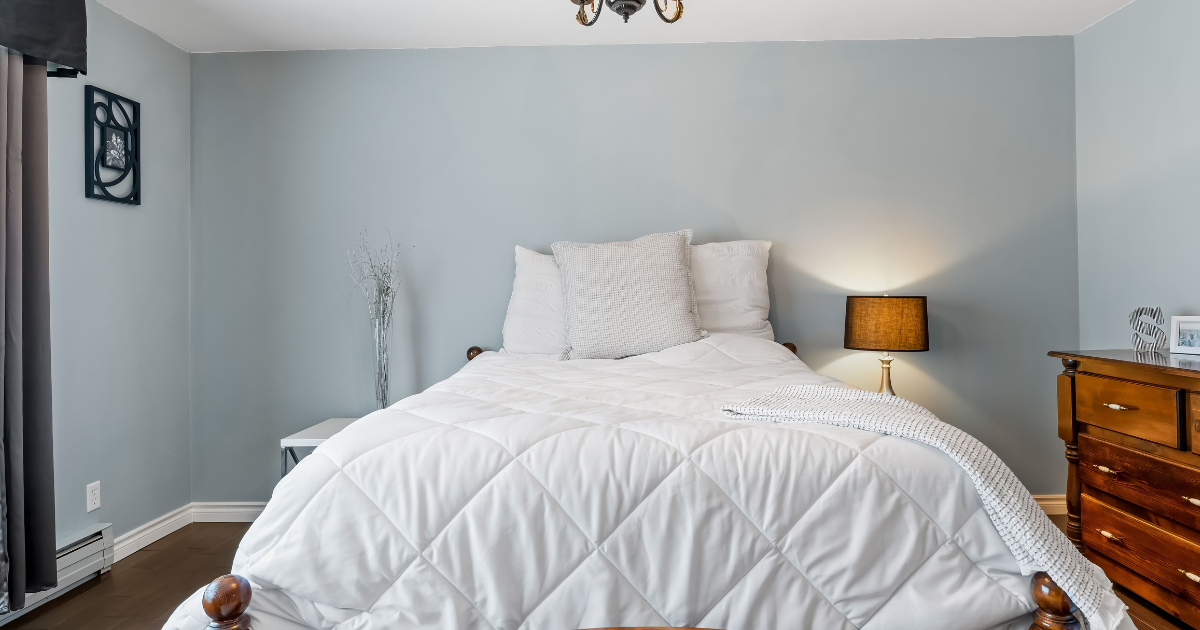 How Often Should You Wash Your Comforter - The WashRoom Laundry Service A fresh, clean white quilted comforter covering a bed. This illustrates the cozy and healthy sleep environment achieved by following guidelines on How Often Should You Wash Your Comforter.