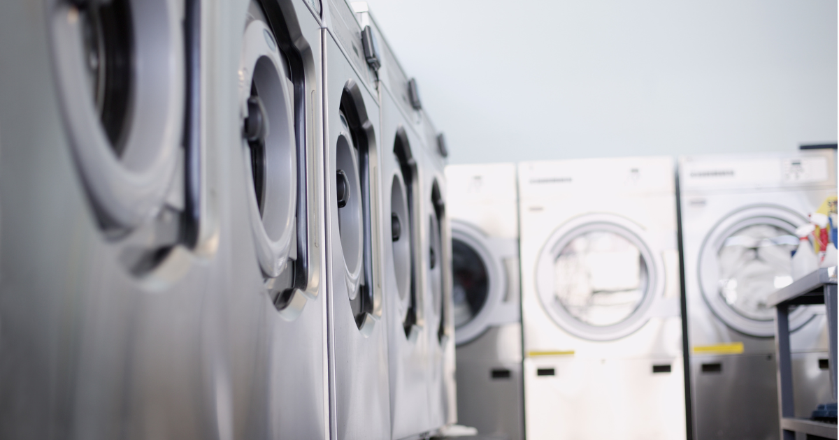 Commercial laundry service with a row of efficient washing machines, illustrating modern eco-friendly laundry equipment.