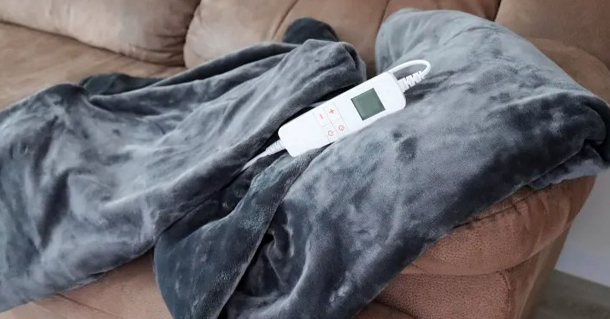 how to wash a heated blanket - The WashRoom Laundry Service A gray electric blanket with its cord and controller sitting on it, illustrating it may be time to consider how to wash a heated blanket